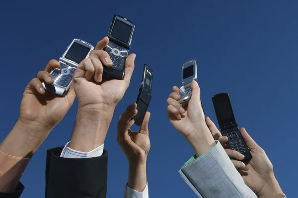 Les mains de l'entreprise tenant des téléphones mobiles — Photo