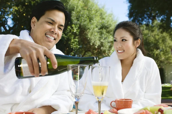Китайская пара носит халаты и пьет шампанское — стоковое фото