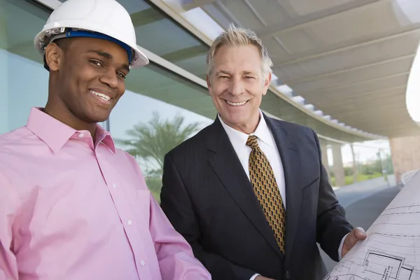 Homme d'affaires et architecte debout avec le plan directeur — Photo