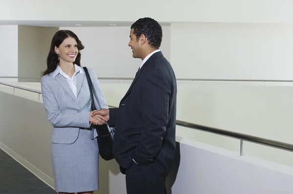 Üzletember üdvözlés női munkatársa irodájában — Stock Fotó