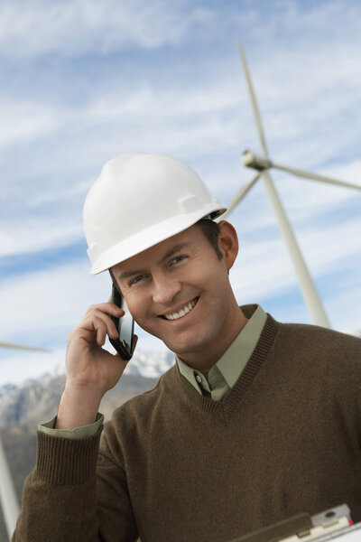 Engineer Using Mobile Phone At Wind Farm