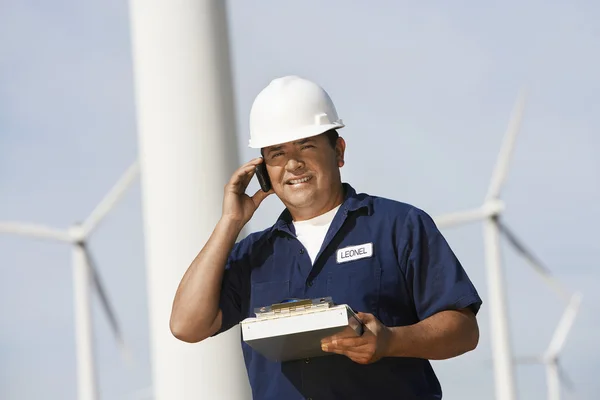 Инженер с помощью мобильного телефона на ветряной электростанции — стоковое фото