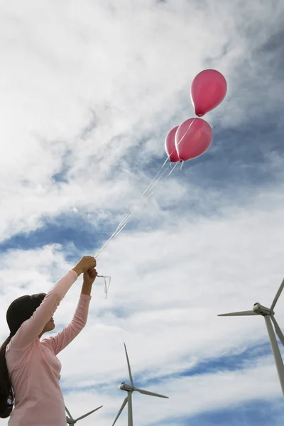 Flicka som leker med ballonger på wind farm — Stockfoto