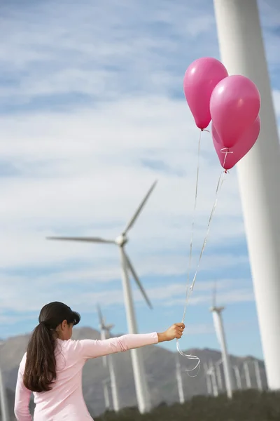 Meisje spelen met ballonnen op wind farm — Stockfoto