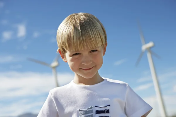 Kleine jongen met windturbines in de achtergrond — Stockfoto