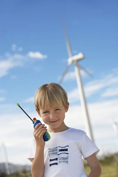男孩抱着玩具对讲机在风电场 — 图库照片