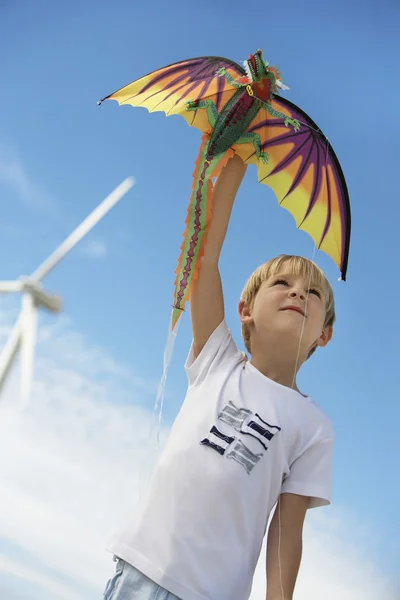 Ragazzo che gioca con aquilone al parco eolico — Foto Stock