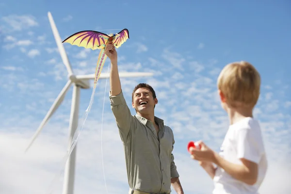 Otec a syn hrát s draka na větrné farmy — Stock fotografie