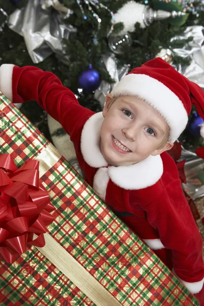 Boy In Santa Claus Outfit Holding Christmas Present Royalty Free Stock Photos