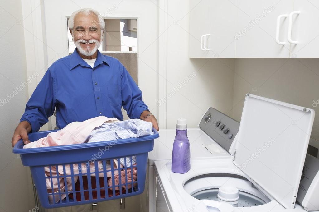  happy senior man with laundry basket 