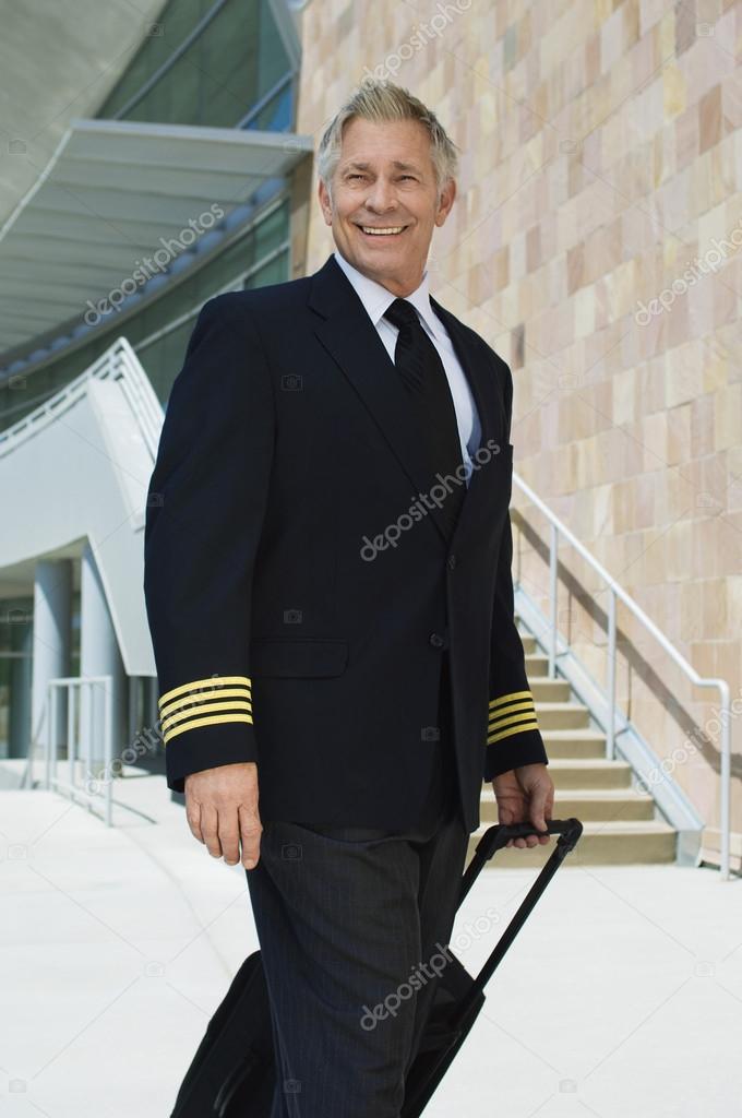 Airline Pilot Pulling Suitcase Outside Building