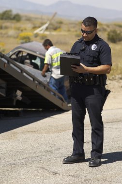 Polis memuru araba kaza mahallinde not yazma