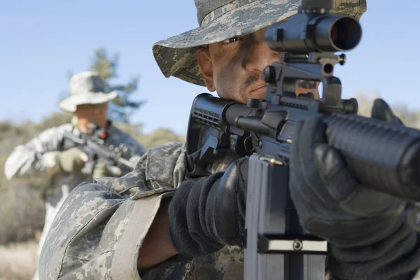 Soldaten zielen mit Gewehren auf Feld — Stockfoto
