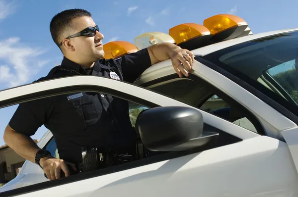 Polizist lehnt an Streifenwagen — Stockfoto