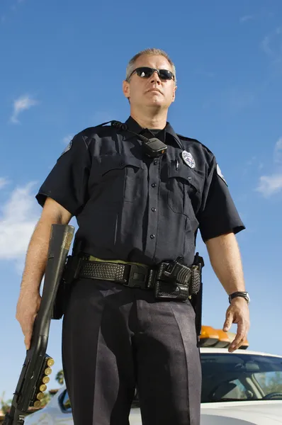Oficial de polícia segurando arma — Fotografia de Stock