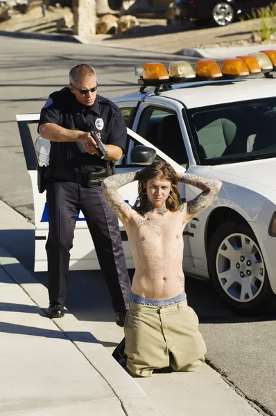 Polizist nimmt jungen Mann fest — Stockfoto