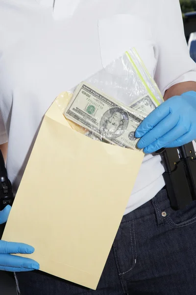 Oficer policji oddanie pieniędzy w kopercie dowodów — Zdjęcie stockowe