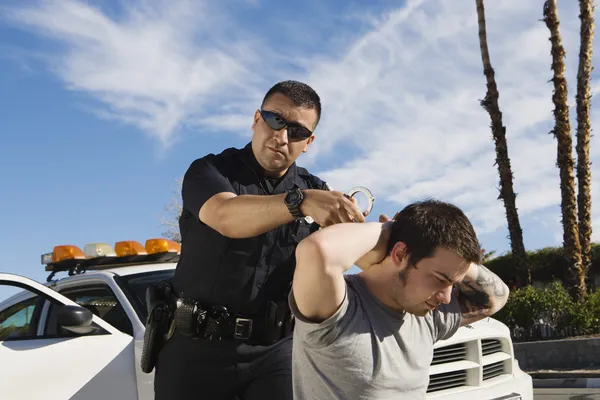 Police Officer Arresting Young Man — Stock Photo, Image