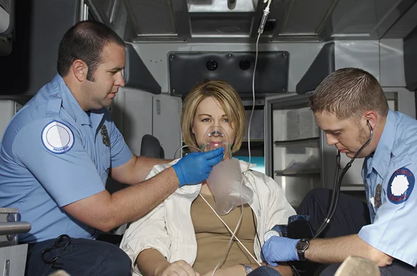 Paramédicos cuidando a la víctima en ambulancia — Foto de Stock