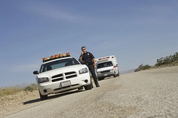 Officier de police debout en voiture de patrouille — Photo