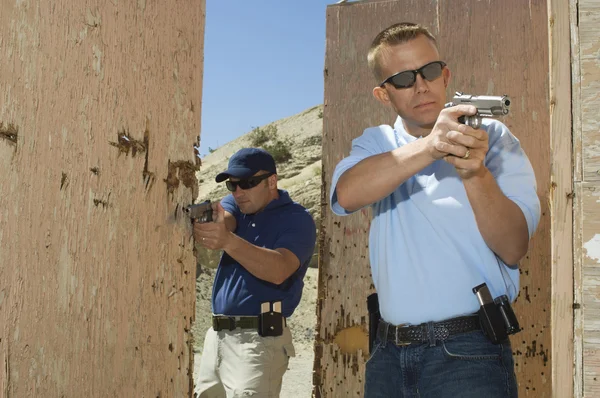 Två officerare syftar hand kanoner på firing range — Stockfoto