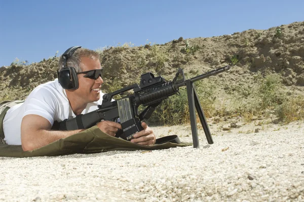 Homem apontando metralhadora — Fotografia de Stock