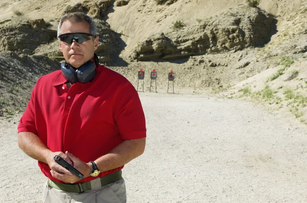 Man Holding Hand Gun At Firing Range — Stock Photo, Image