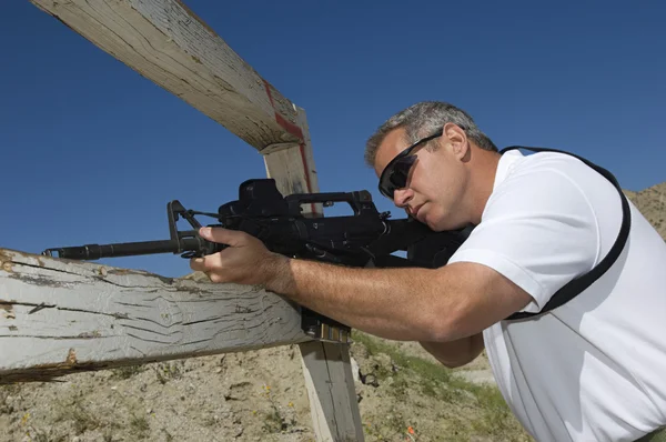 Homem apontando rifle em alcance de fogo — Fotografia de Stock