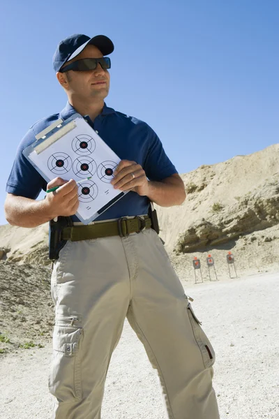 Instrutor segurando a área de transferência com diagrama de destino — Fotografia de Stock