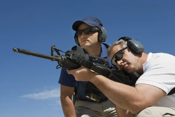 Instructor With Man Aiming Machine Gun — Stock Photo, Image