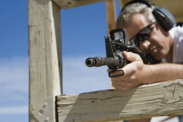 Mann zielt mit Maschinengewehr auf Schießstand — Stockfoto