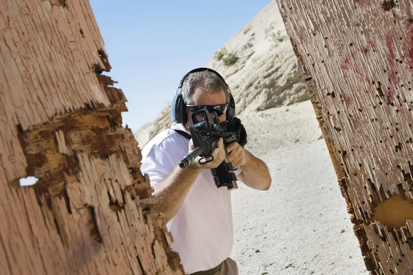 Hombre apuntando ametralladora en campo de tiro — Foto de Stock