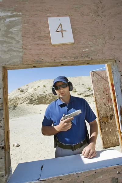 Mężczyzna trzyma rękę pistolet w zakresie zwalniania — Zdjęcie stockowe
