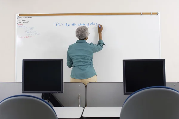 Senior lärare skriva på whiteboard — Stockfoto