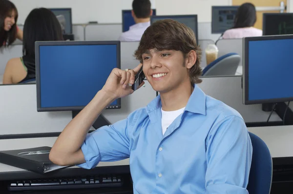 Estudante do sexo masculino comunicando no telefone móvel — Fotografia de Stock