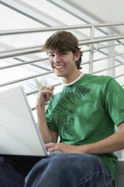 Jovem estudante usando laptop — Fotografia de Stock