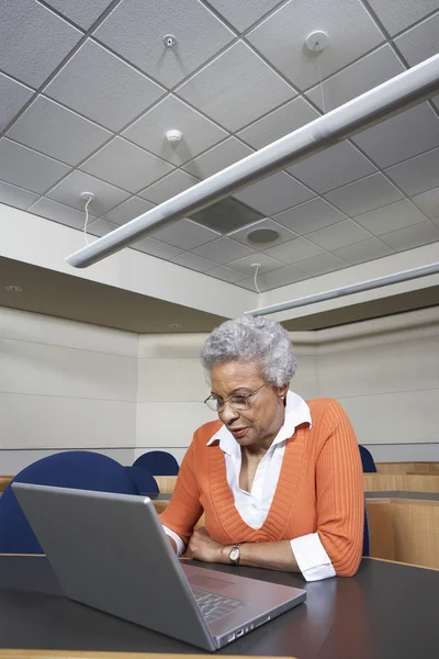 Senior docent die op laptop werkt — Stockfoto