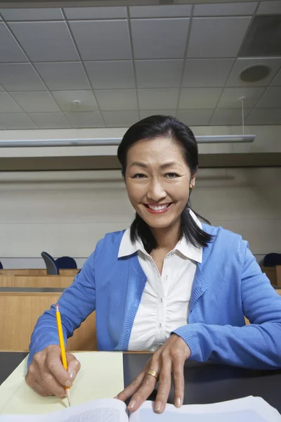 Vrouwelijke professor noteren van notities op papier — Stockfoto