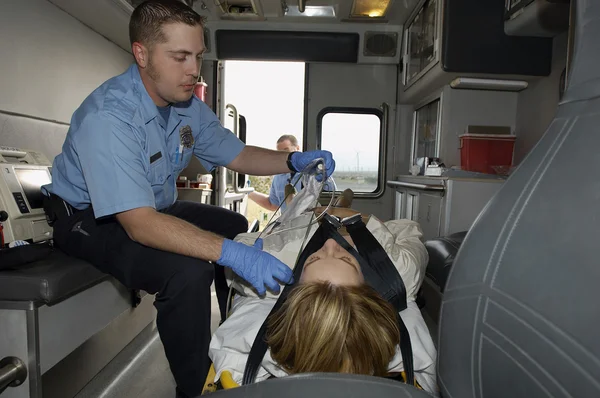 Paramedic With Victim In Ambulance Stock Photo