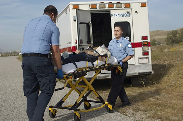 Paramedici vervoer slachtoffer op brancard Stockfoto