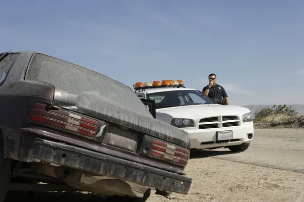 Police Officer Using CB Radio on roadside Stock Picture