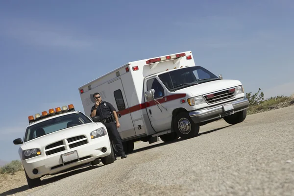 Police Officer By Patrol Car And Ambulance Stock Photo