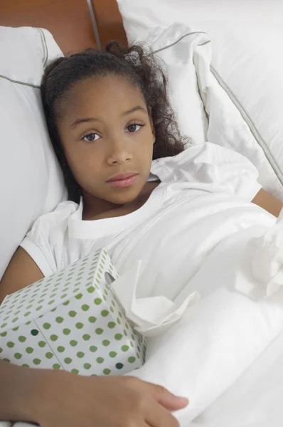 Dívka s tkáně box v postel — Stock fotografie