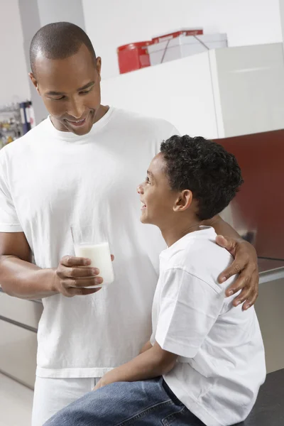 Homme donnant un verre de lait à son fils — Photo