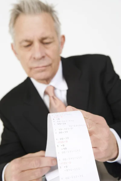 Uomo d'affari guardando carta calcolatrice — Foto Stock