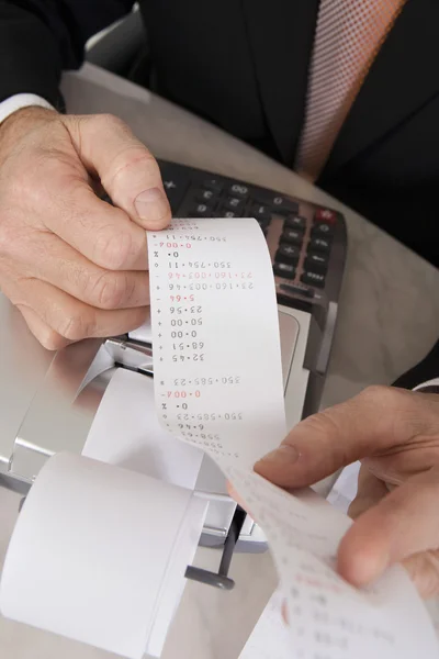 Empresario sosteniendo papel calculadora — Foto de Stock