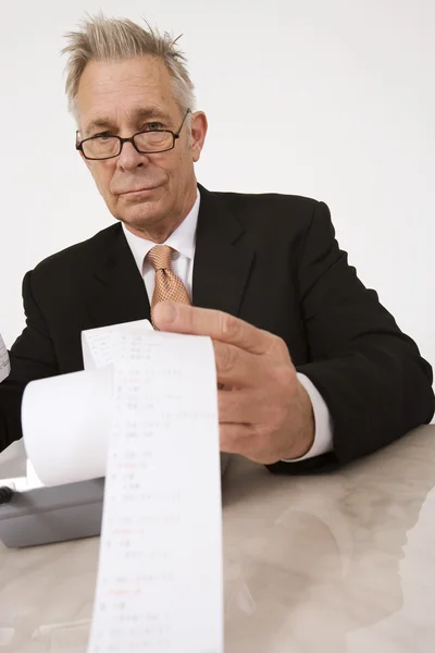 Бизнесмен с калькуляторной бумагой — стоковое фото