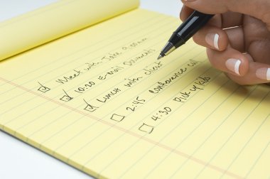 Closeup dişinin el yazma yapmak için görev listesi