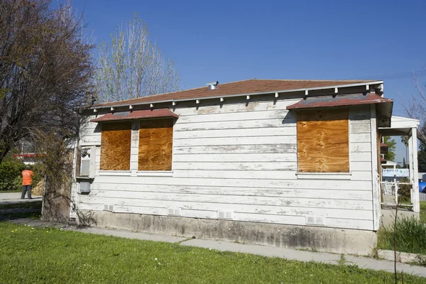 Pencereleri tahtayla kapatılmış terk edilmiş bir ev. — Stok fotoğraf
