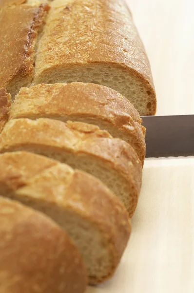 Knife slicing  baguette — Stock Photo, Image